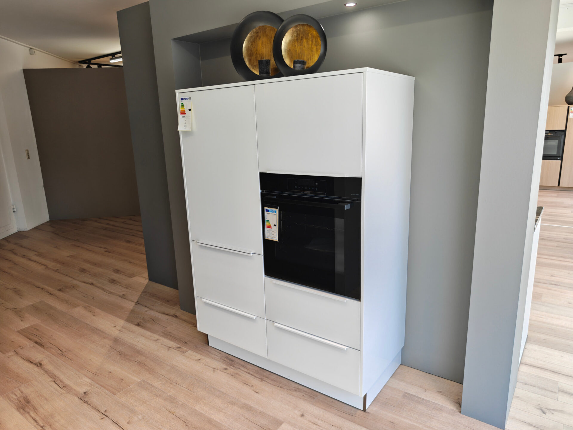 Separater weißer Geräteschrankbereich mit Kühlschrank und Backofen
