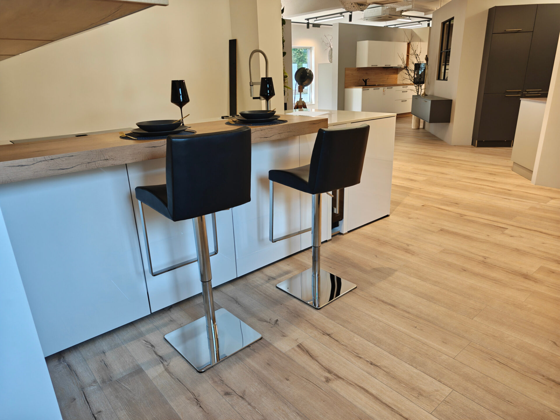 Barseite der weißen Küche mit Holztheke